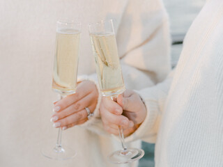 Friends celebrating with champagne flutes at a scenic location during sunset
