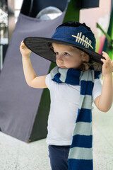 A little girl is wearing a magician's costume featuring a playful hat and scarf. She appears...