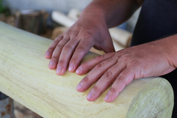 Carpenter hands on wooden log close-up