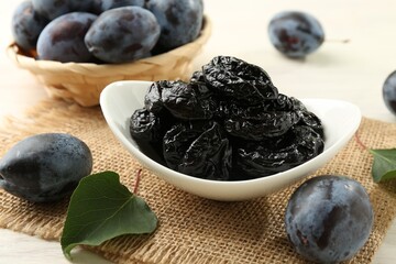 Dried prunes and fresh plums on table, closeup