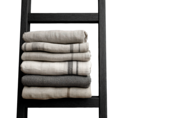 A stack of clean folded linen towels on a black ladder rack.