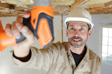 male holds a drill indoors