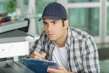 man technician repairing a printer