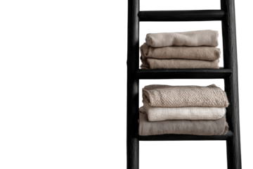 Folded neutral colored towels stacked on a black decorative ladder shelf.