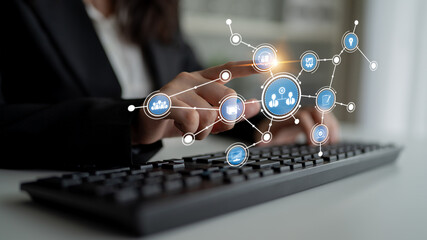 A business professional interacts with a keyboard while digital connection icons appear, symbolizing networking and technology in a modern office setting. Tessel