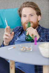 man passed out on the couch with beer and joint