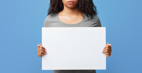 Public demonstration concept. Serious african american woman protesting with blank placard, empty...