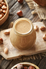 Homemade hazelnut butter in a glass jar on a table