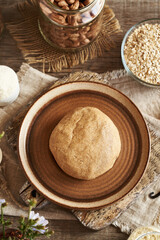 Ball of raw dough made of whey protein powder, ground oat flakes, vanilla and nut butter - preparation of homemade bars