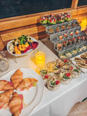 A diverse buffet spread on a yacht boat deck, ready for guests. Catering buffet for events. Catering banquet table with different food snacks and appetizers with sandwich, salads, fresh fruits. 