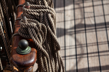 Coiled ropes laying on a wooden sailboat deck. Maritime environment, nautical craftsmanship and attention to detail concepts.