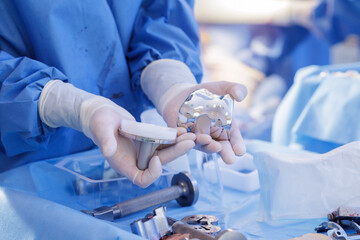 Surgeon holding knee replacement prosthesis components in a sterile orthopedic setting