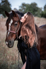 Obraz premium Young beautiful sexy woman in a cloak and lace lingerie corset is walking with a horse in nature. Freedom. Friendship and loyalty. Peace of mind. Portrait. 