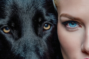A striking close-up of a human and a black dog showcasing intense eye contact, highlighting the bond and connection between humans and animals through their captivating eyes