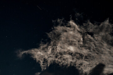 Stars through the clouds in the night sky