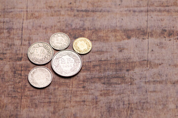 Swiss franc coins on a wooden background