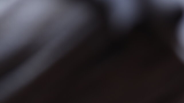 Dark abstract blur with soft light gradients, low focus texture blending muted shadows and subtle highlights