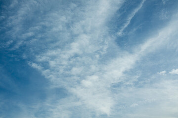 Blue sky with scattered white clouds in soft daylight. Fine high-altitude textures create a clean natural backdrop.