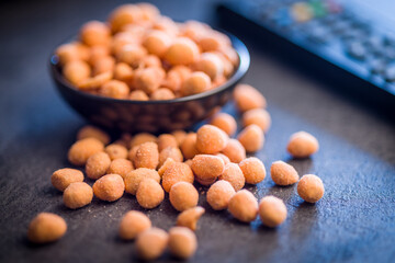 Peanuts in a crispy crust on black table.