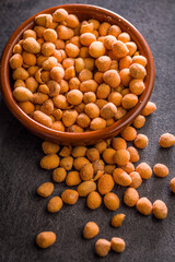 Peanuts in a crispy crust in bowl on black table.