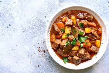 Goulash (meat stew with tomatoes and paprika) - traditional dish of hungarian cuisine .Top view with copy space.