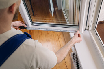 Repairman installing a pvc window frame in a residential apartment