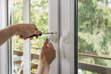 Repairman installing a pvc window frame in a residential apartment