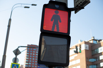 Red pedestrian traffic light in the city with a clear view of the digital display showing a person...