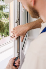 Repairman installs PVC window frame for improved energy efficiency