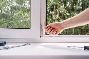 Repairman installing a PVC window frame in a residential setting