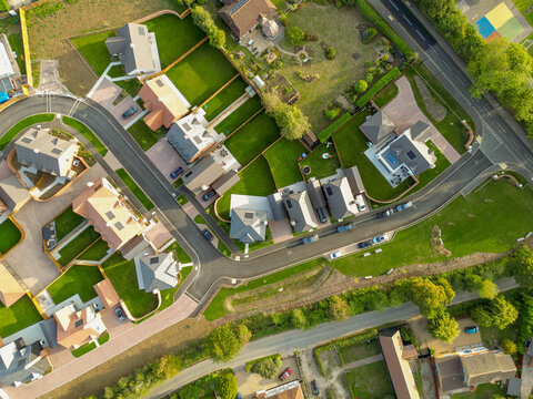 Drone top down view of newly purchased homes seen in a British housing development site. Smaller, first time buyer homes are on the left, further into the estate.