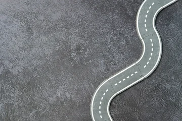 Fotobehang Formule 1 Miniature toy road with white markings on textured dark surface.  © photoguns