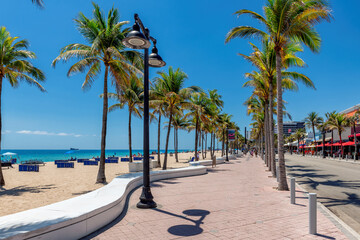 Seafront promenade and wonderful beach with palm trees on a sunny summer day in Fort Lauderdale, Florida.