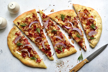 Tart flambe ( tarte flambee ) - onion pie with soft cheese and smoked bakon. Top view  with copy space.