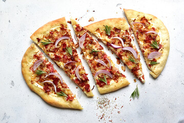 Tart flambe ( tarte flambee ) - onion pie with soft cheese and smoked bakon. Top view  with copy space.