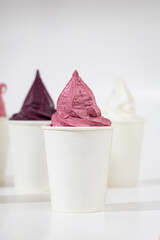Colorful berry ice cream in paper cup isolated on white background. Minimal food concept