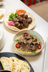 Beef tongue with hummus and grilled vegetables in a modern restaurant setting