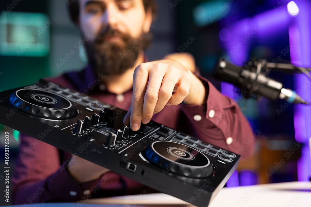 Poster close up shot of artist filming dj mixing tutorial, showing examples of sampling on sound controller