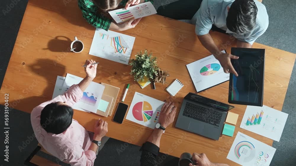 Aufkleber top down aerial view of business man pointing and presenting at financial chart while diverse team d