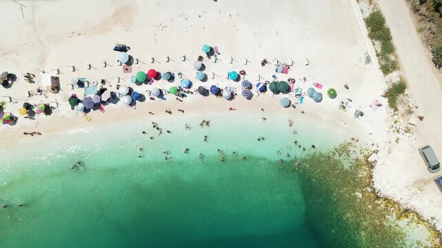 Porto Vathy beach, sand and umbrellas on beach, Thassos Island, Greece. One of the most beautiful beaches in Greece. Amazing beach with clear blue water. Aerial panoramic drone view from above, top vi
