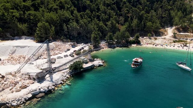 Porto Vathy beach, sand and umbrellas on beach, Thassos Island, Greece. One of the most beautiful beaches in Greece. Amazing beach with clear blue water. Aerial panoramic drone view from above, top vi