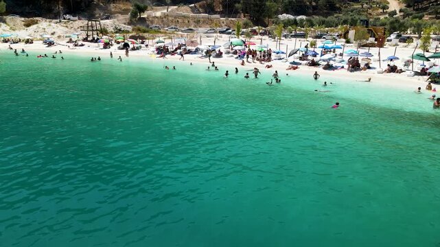Porto Vathy beach, sand and umbrellas on beach, Thassos Island, Greece. One of the most beautiful beaches in Greece. Amazing beach with clear blue water. Aerial panoramic drone view from above, top vi