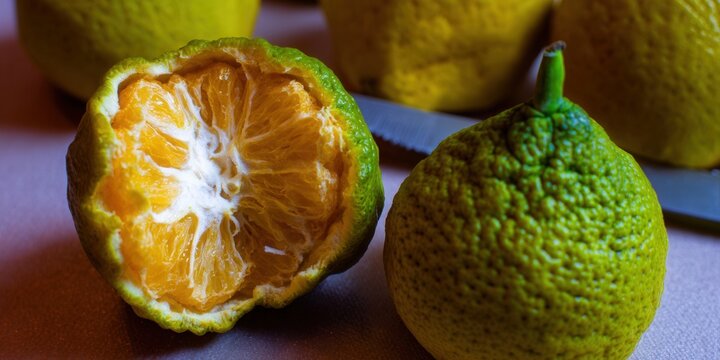 A vibrant image showing a partially peeled ugli fruit, ready to eat, with a whole one beside.
