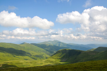 Breathtaking mountain range with lush green valleys and hills under a dramatic sky filled with clouds, emphasizing a peaceful connection with nature. Carpathian Mountains, Ukraine