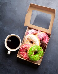 Assorted donuts in a cardboard box with coffee