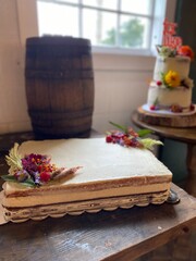 Cakes with Flowers Near Window with Wine Barrel in Rustic Barn
