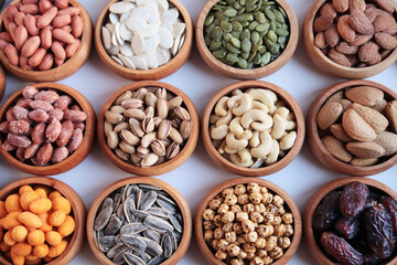 Various luxury nuts were designed in bamboo bowls on a white surface.Large group and top view	