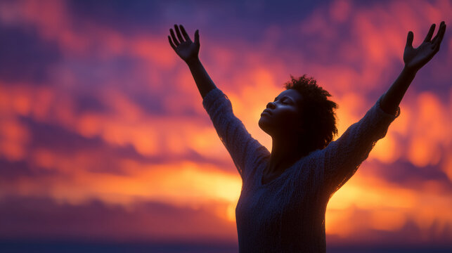 Silhouette of woman with hands raised in prayer at sunset, glowing horizon with soft clouds, symbolizing spirituality, faith, devotion, and inner peace. SEO keywords: woman praying