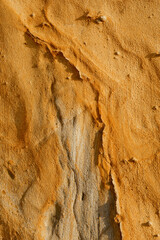 Natural texture background of sandstone rocks with lines, curves, prints in the As Amoeiras and Formosa beach cliffs in Santa Cruz, Portugal.