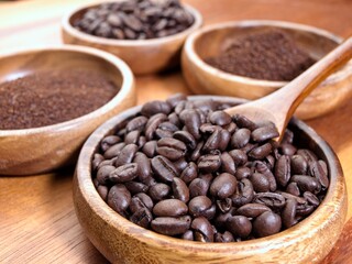  Wooden spoon and coffee beans in bowl.